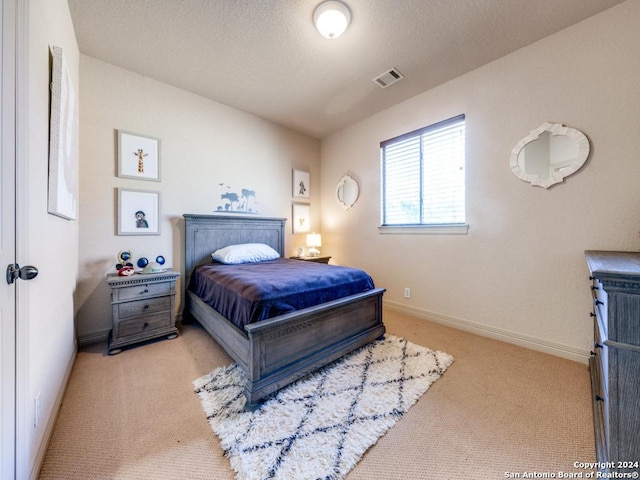 bedroom with carpet, baseboards, visible vents, and a textured ceiling