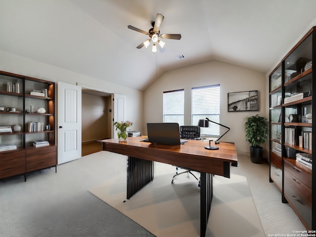 office area featuring light carpet, visible vents, ceiling fan, and lofted ceiling