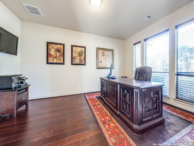 office space featuring dark wood finished floors, visible vents, and baseboards