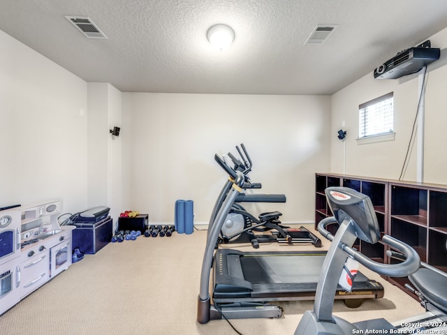 workout area with carpet flooring and a textured ceiling