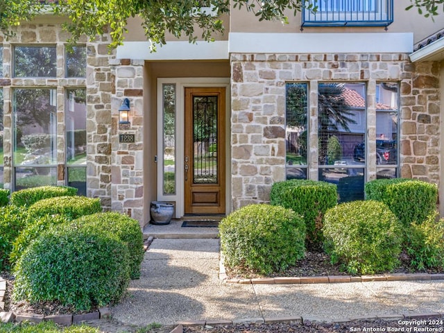 property entrance with stucco siding and stone siding