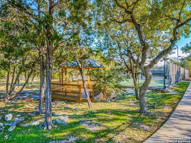 exterior space featuring a gazebo, fence, and a tennis court