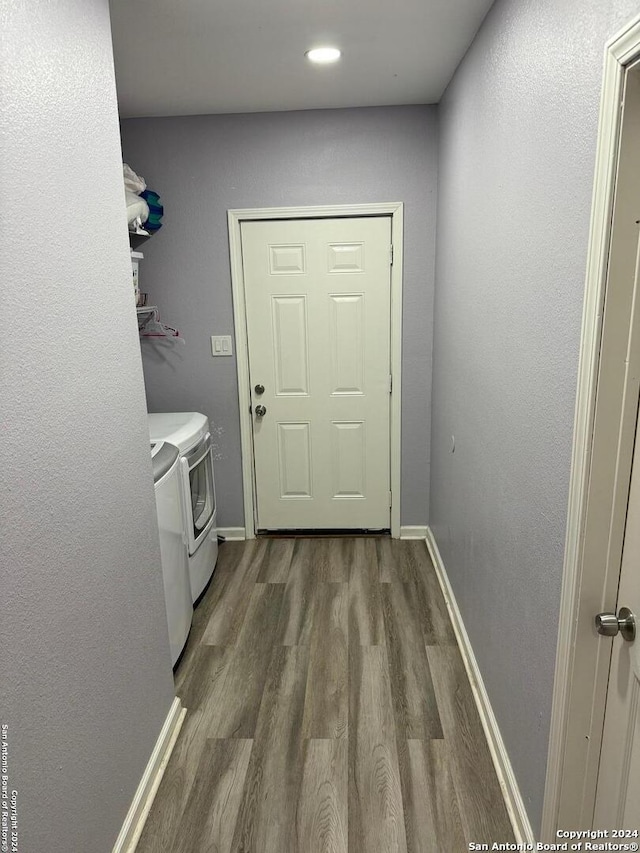 clothes washing area with washer and dryer and wood-type flooring