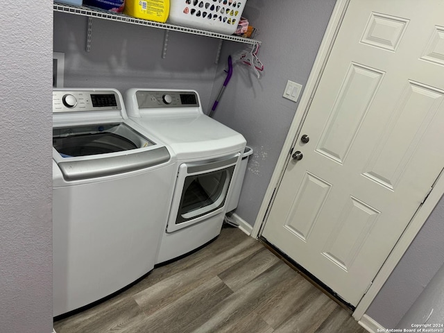 laundry room featuring wood-type flooring and washing machine and dryer