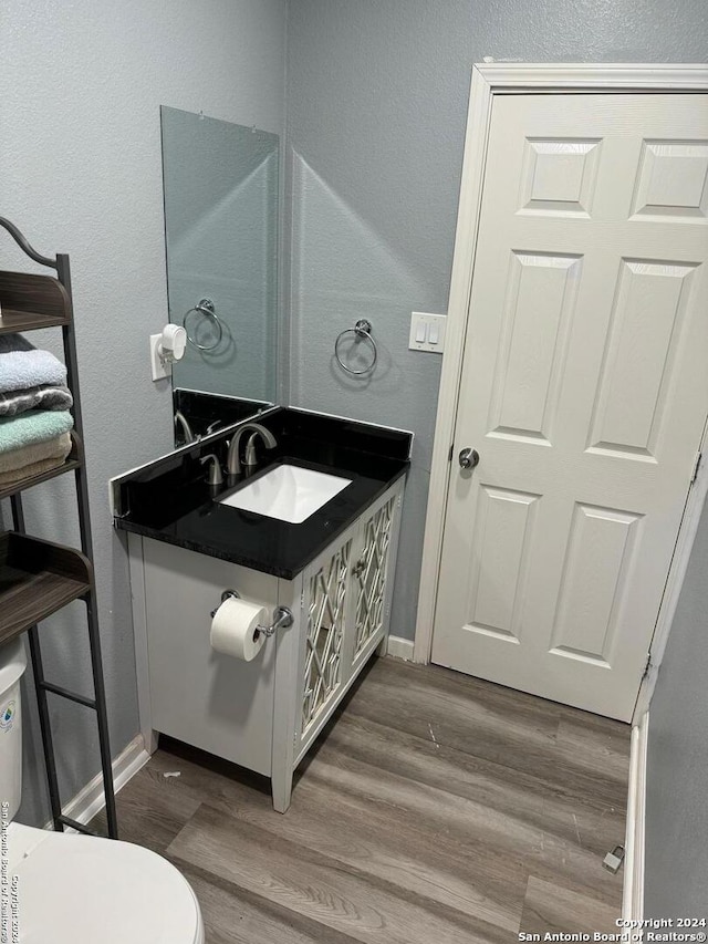 bathroom featuring hardwood / wood-style flooring, toilet, and sink