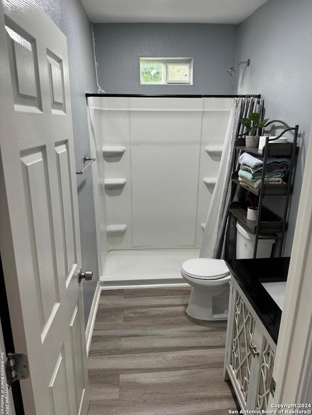 bathroom featuring a shower with curtain, toilet, vanity, and hardwood / wood-style flooring