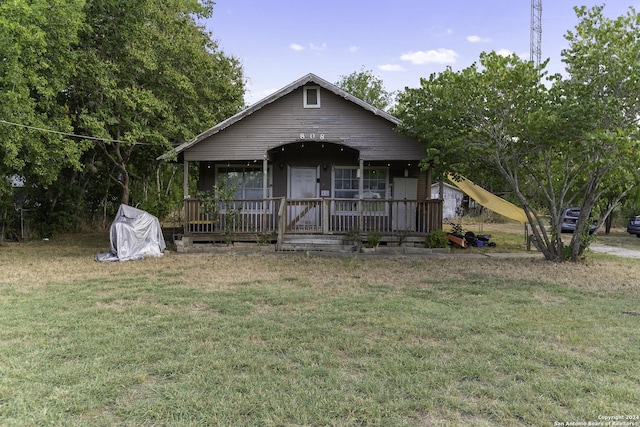 bungalow-style house with covered porch and a front lawn