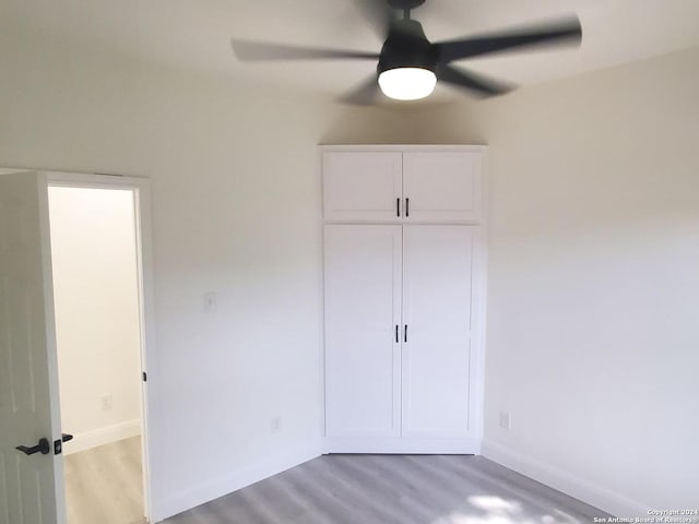 unfurnished bedroom with wood-type flooring, a closet, and ceiling fan