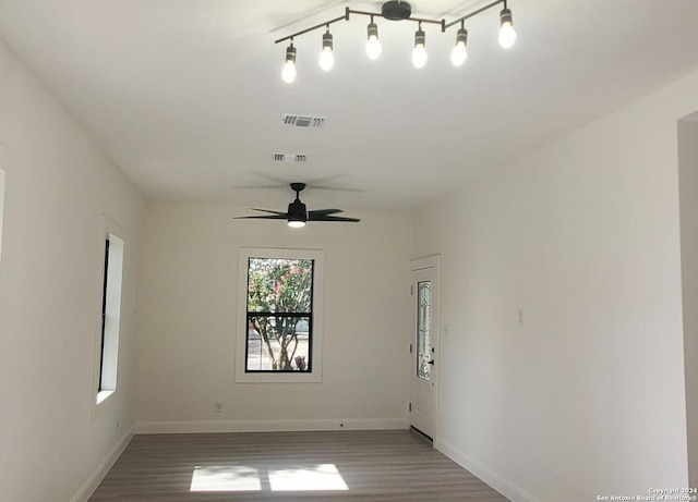 spare room featuring hardwood / wood-style floors, rail lighting, and ceiling fan