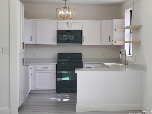 kitchen with decorative light fixtures, black appliances, white cabinetry, wood-type flooring, and sink