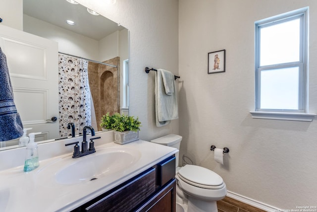 bathroom with a shower with shower curtain, vanity, and toilet