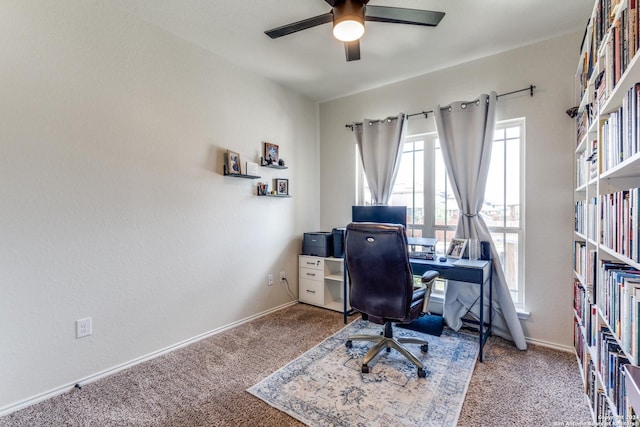 carpeted home office featuring ceiling fan