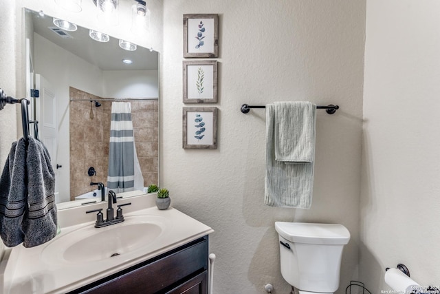 bathroom featuring a shower with shower curtain, vanity, and toilet