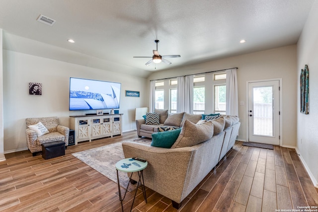 living room featuring ceiling fan, plenty of natural light, and vaulted ceiling