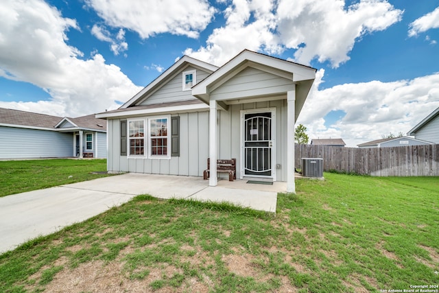 view of front of house featuring central air condition unit, a front lawn, and a patio area