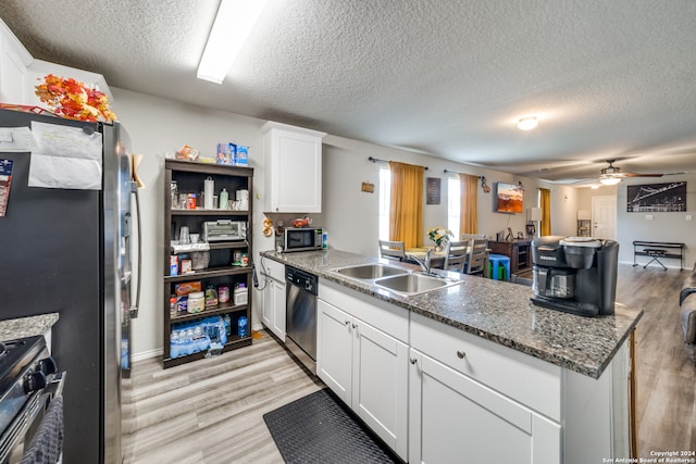 kitchen featuring ceiling fan, white cabinets, sink, appliances with stainless steel finishes, and light hardwood / wood-style flooring