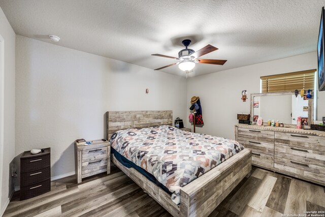 bedroom featuring wood-type flooring, a textured ceiling, and ceiling fan