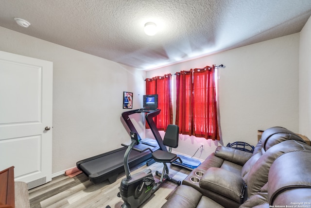 exercise area featuring a textured ceiling and hardwood / wood-style floors