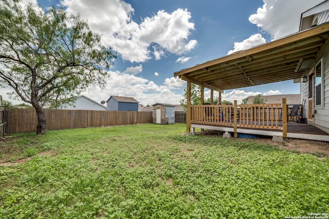 view of yard with a wooden deck and a storage shed