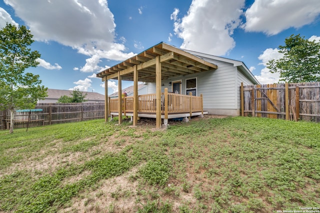 rear view of house with a deck and a yard