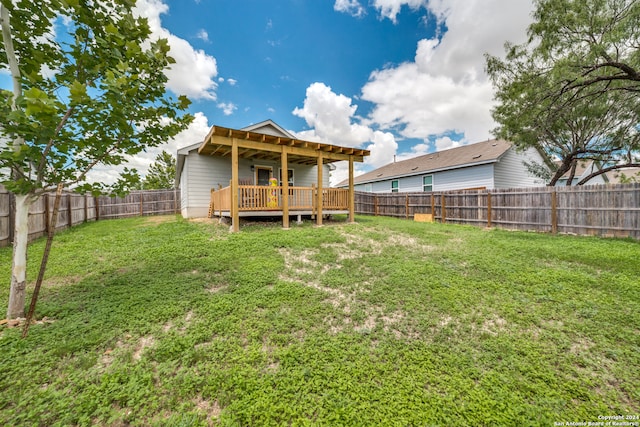 rear view of house with a lawn and a wooden deck