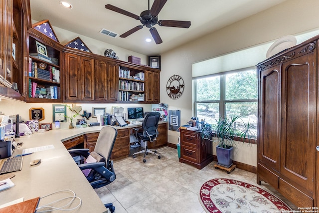 tiled office space with built in desk and ceiling fan