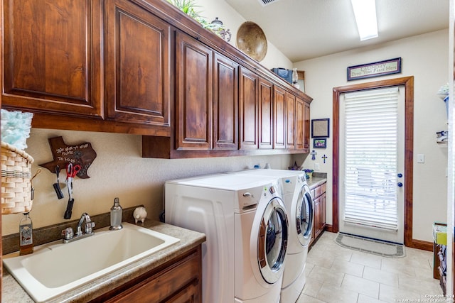 laundry area featuring washer and clothes dryer, cabinets, light tile patterned floors, and sink