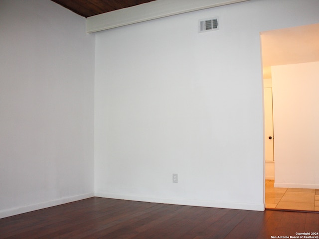 empty room with wood ceiling and hardwood / wood-style floors