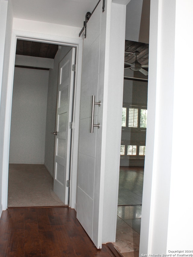 hall featuring carpet flooring and a barn door