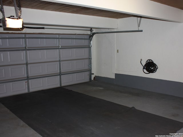 garage featuring a garage door opener and wood ceiling