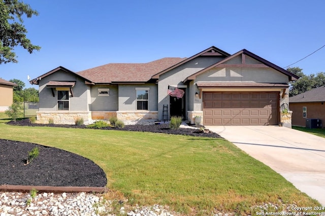 view of front of home featuring a garage, a front lawn, and cooling unit