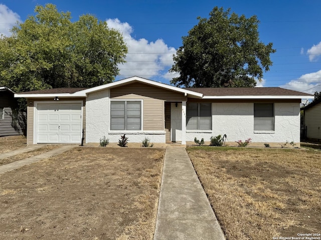 ranch-style home with a front lawn and a garage