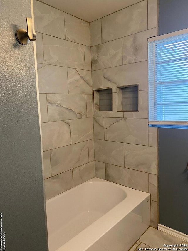 bathroom featuring tile patterned floors and tiled shower / bath combo