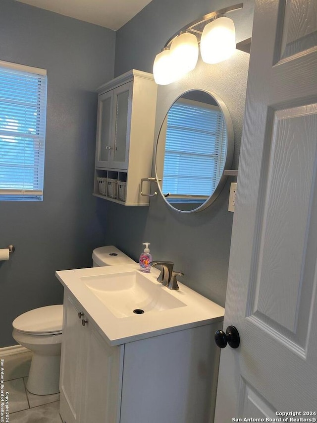 bathroom with tile patterned flooring, vanity, and toilet