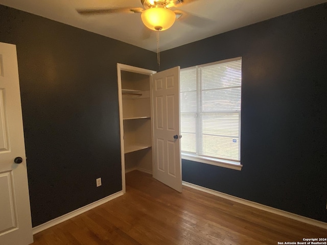 unfurnished bedroom with hardwood / wood-style floors, a closet, and ceiling fan