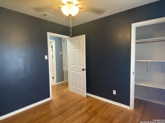 unfurnished bedroom featuring wood-type flooring, a closet, and ceiling fan