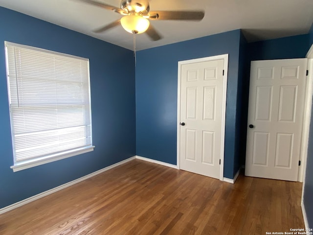 unfurnished bedroom featuring dark hardwood / wood-style floors and ceiling fan