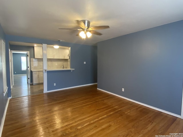 unfurnished living room with ceiling fan and dark hardwood / wood-style flooring