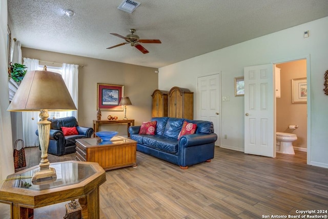 living room featuring a textured ceiling, ceiling fan, and hardwood / wood-style floors