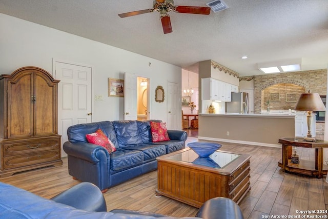 living room featuring brick wall, a textured ceiling, hardwood / wood-style flooring, and ceiling fan