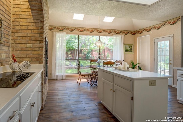 kitchen with white cabinetry, a center island, and a textured ceiling