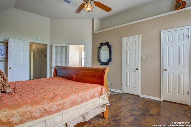 bedroom featuring two closets, dark hardwood / wood-style floors, ceiling fan, and vaulted ceiling