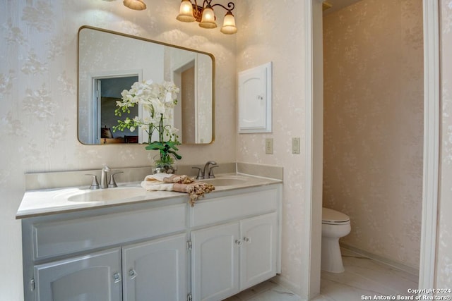 bathroom with tile patterned flooring, double vanity, and toilet