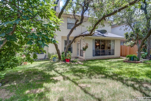 rear view of house featuring a lawn