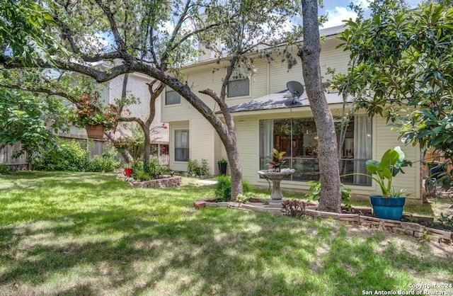 rear view of property with a yard