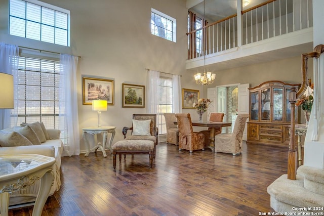 living room featuring a healthy amount of sunlight, hardwood / wood-style flooring, and a towering ceiling