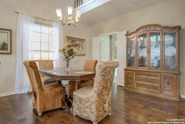 dining space with dark hardwood / wood-style floors and a notable chandelier