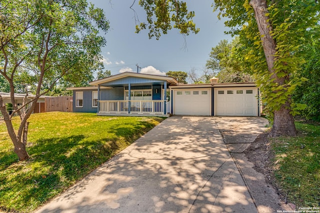 view of front of property with a porch, a garage, and a front yard