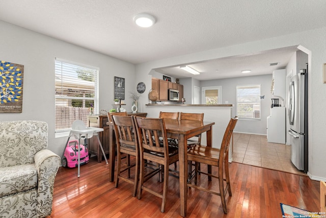 dining area featuring light hardwood / wood-style flooring and a textured ceiling