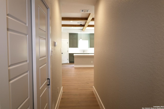 corridor with beam ceiling and hardwood / wood-style floors